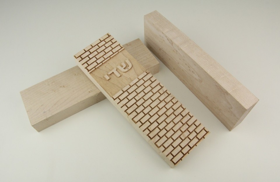 Laser engraving on a maple mezuzah in a jewish design