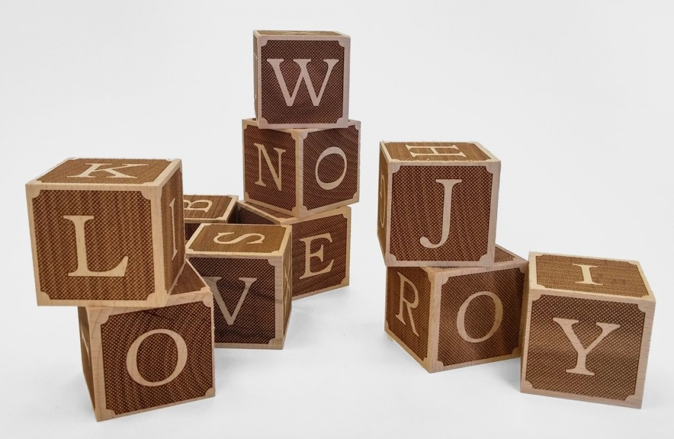 latters engraved with laser over a wooden playing cubes