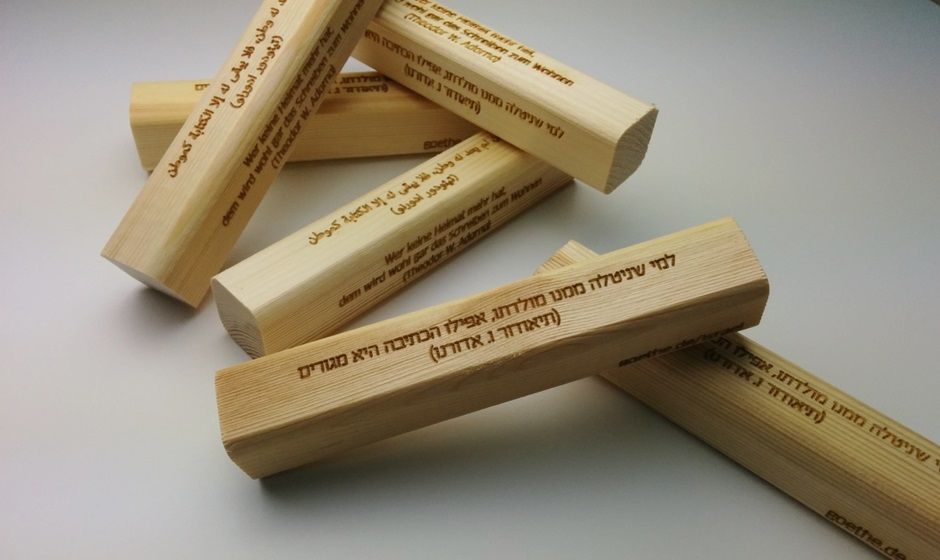 Laser engraving of famous quotes in several languages on a pine wood